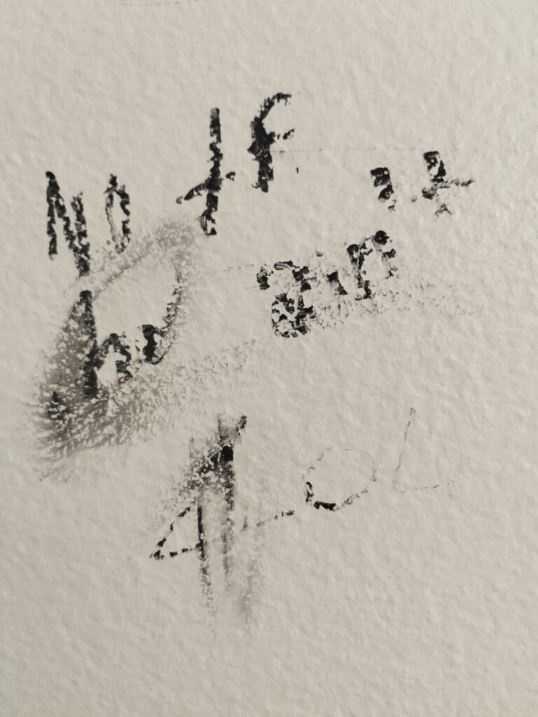 Smudged and very hard to read graffiti drawn on a surface that reads "No tf he ain't LOL" [i.e. presumably 'Not if he ain't, LOL', in reference to previous graffiti saying 'Jesus is the prince of peace']